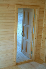 Opened door inside new built wooden house. Vertical view