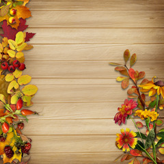 Border and a bouquet of autumn leaves on a wooden background