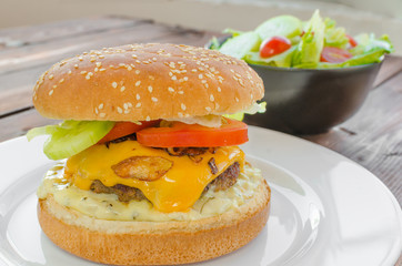 Cheeseburger with bacon and tartar sauce and garden salad