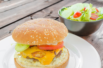 Cheeseburger with bacon and tartar sauce and garden salad