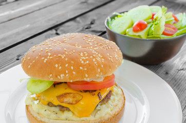 Cheeseburger with bacon and tartar sauce and garden salad