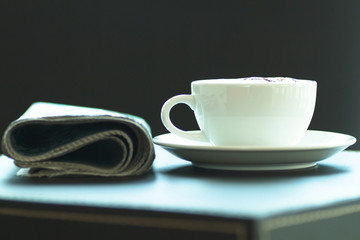 Fototapeta premium Cup of coffee with the newspaper in the brakes.