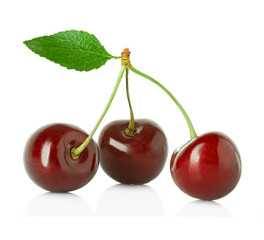 Sweet cherries with the leaf isolated on a white background.