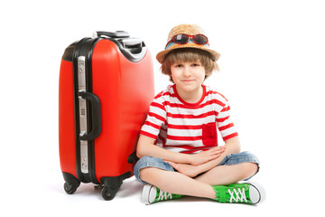 The summer boy sits with red trunk