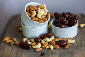An assortment of healthy nuts in a bowl : almond, cashew, dates