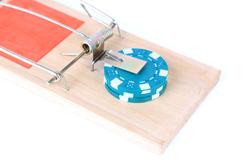 Mousetrap and casino chip isolated on white