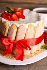 Tasty cake Charlotte with fresh strawberries on wooden table