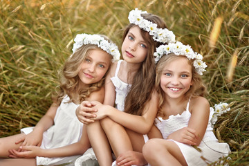 Portrait of three young girlfriends with a wreath