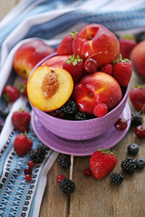 Peaches and berries in bowl on table close-up