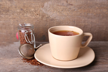 Cup of tasty rooibos tea, on wooden table