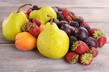 Ripe fruits and berries on wooden background