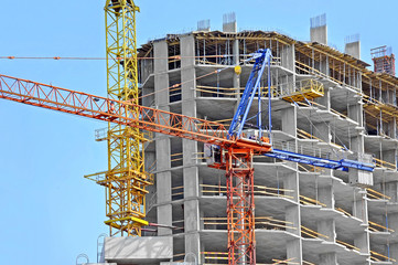 Crane and building construction site against blue sky