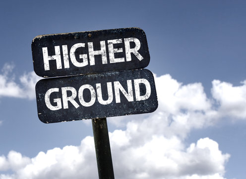 Higher Ground sign with clouds and sky background