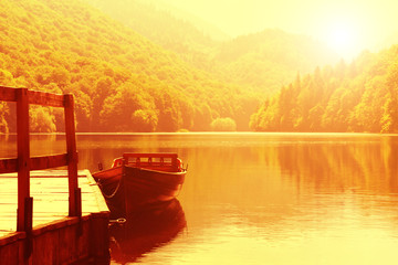 Wooden boat at pier on mountain lake