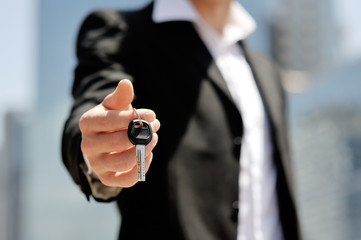 businessman holding a car key in his hand
