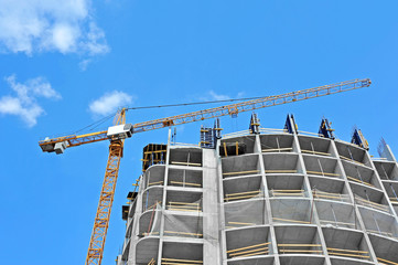 Crane and building construction site against blue sky