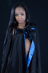 Black woman in black cape, looking with friendly expression