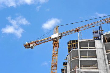 Crane and building construction site against blue sky