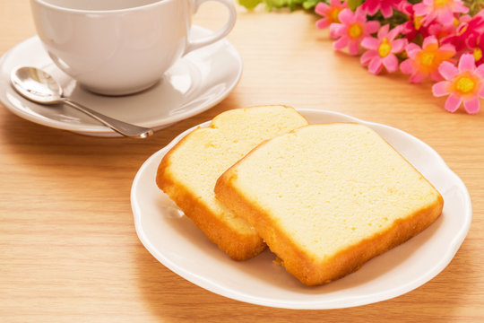 Butter cake sliced on plate and coffee cup, filtered image