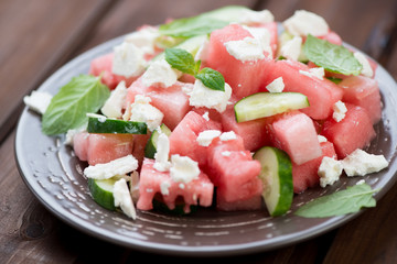 Close-up of watermelon, cucumber and feta salad on a glass plate