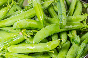 Fresh green pea pods in a bowl
