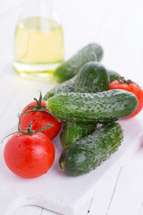 Fresh cucumbers and tomatoes on wooden background