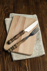 cutlery on a cutting board with linen napkin