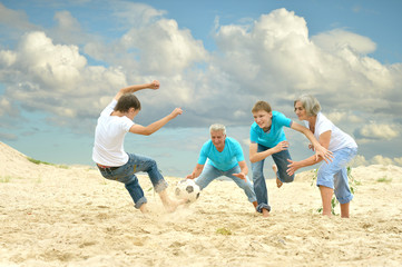 Family playing football on a beach