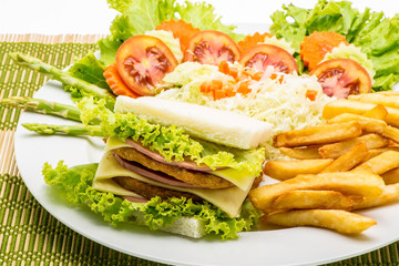 chicken sandwich on a white plate with french fries.