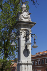 Fototapeta na wymiar Streetlights on ancient decorated stone column