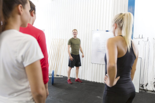 Personal trainer instructs fitness workout team
