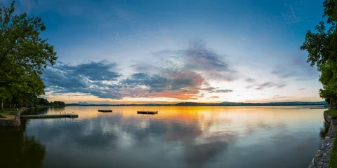 Foto op Canvas panorama of lake wallersee at sunset with trees and clouds © A2LE
