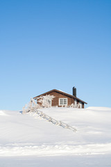 Hütte im Winter mit Schnee und blauem Himmel