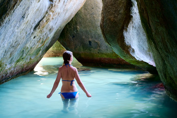 Young woman at cave on tropical beach