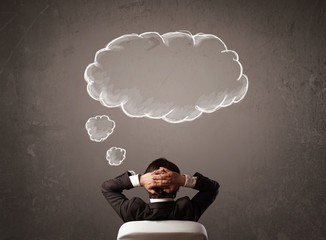 Businessman sitting with cloud thought above his head