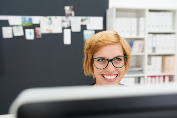 frau am pc schaut lachend nach oben