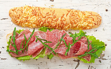 Big sandwich with salami, lettuce and arugula