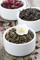Assorted dry herbal teas in white bowls, close-up