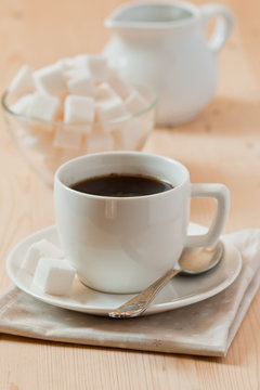 White cup of coffee with chocolate and sugar in wooden table