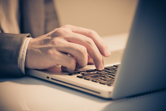 Hands of a man working with laptop