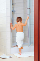 cute kid ready to wash himself in shower © Olesia Bilkei