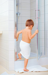 cute kid ready to wash himself in shower © Olesia Bilkei
