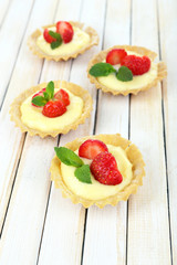 Tasty tartlets with strawberries on table close-up