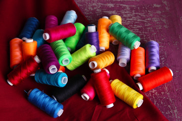 Multicolor sewing threads on wooden background