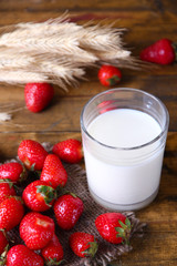 Ripe sweet strawberries and glass with milk