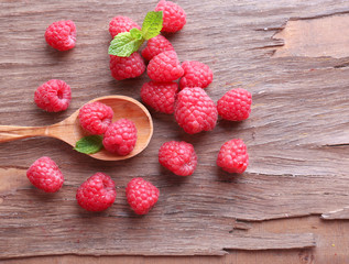 Ripe sweet raspberries in spoon on table close-up