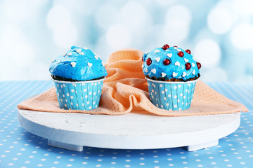 Tasty cupcake on table, on bright background