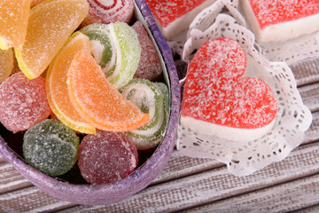 Present box with sweets on wooden background