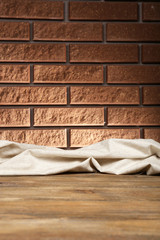 Wooden table with cloth on wall background