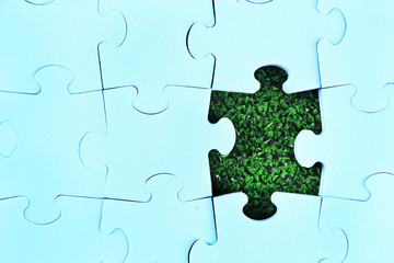 Puzzle pieces on green grass background. Green space concept
